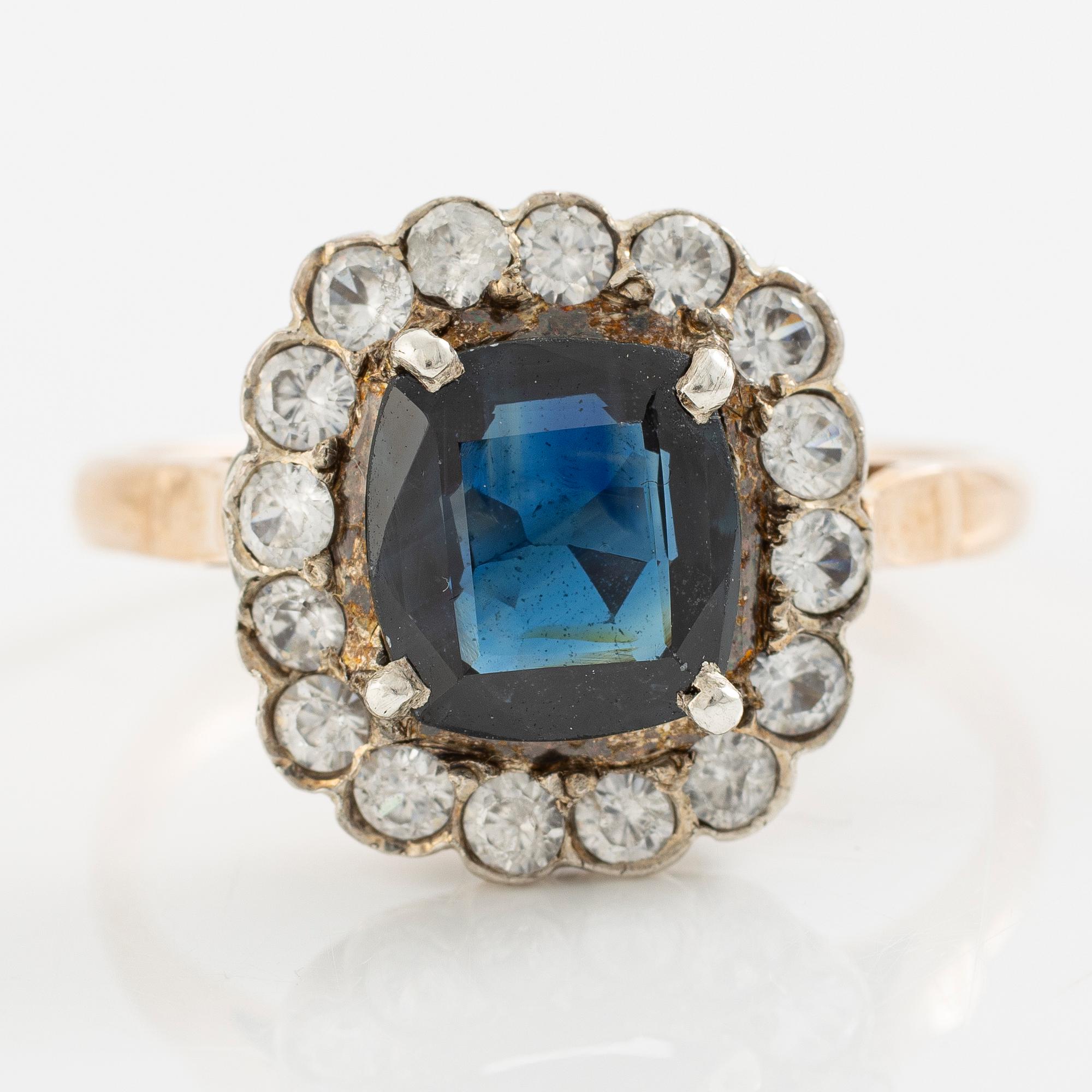 Ring in low carat gold with dark sapphire and white stones.