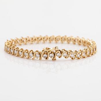 A 14K gold tennis bracelet, with brilliant-cut diamonds.