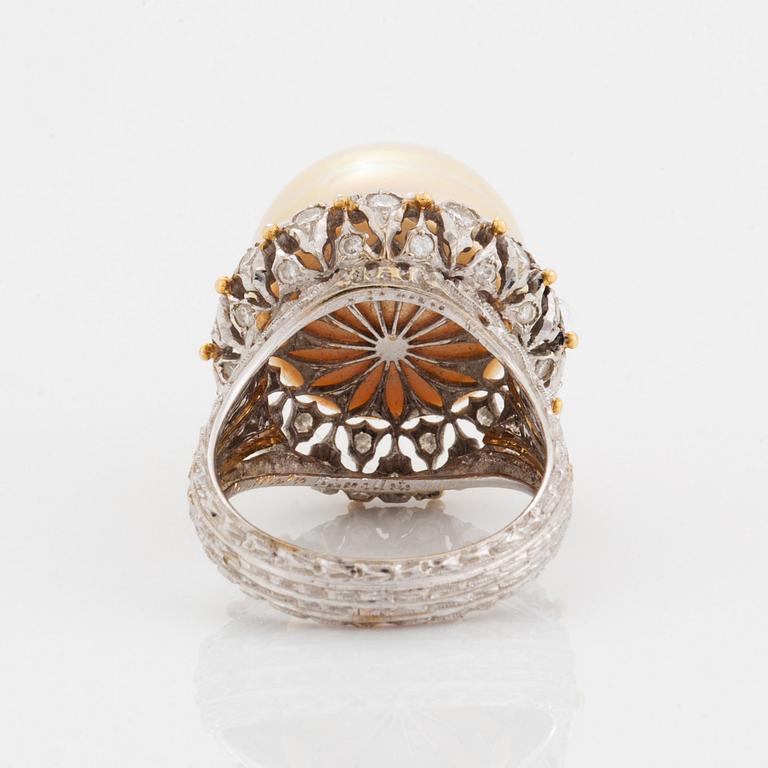 An 18K gold ring set with a cultured pearl and round brilliant-cut diamonds.