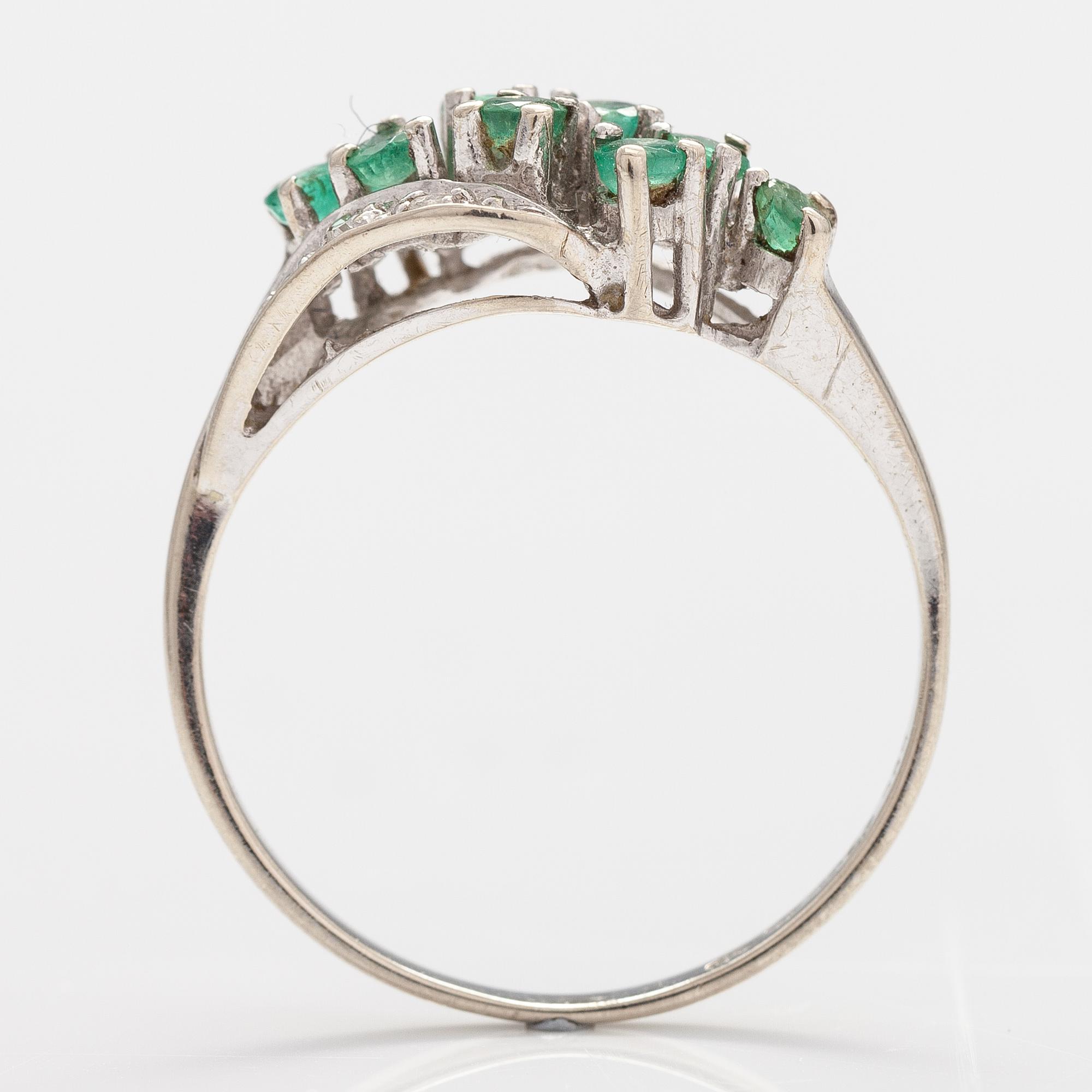 A 14K white gold ring with emeralds and diamonds ca. 0.02 ct in total. Import marked Turun Hopea, Turku 1995.