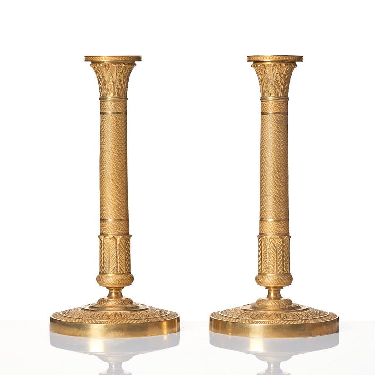 A pair of French Empire ormolu candlesticks, early 19th century.