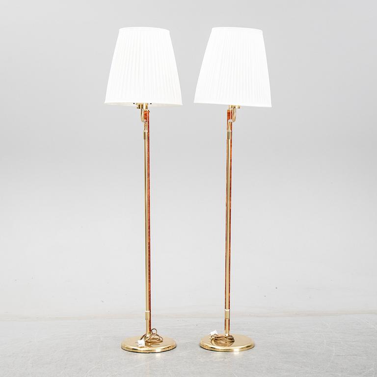 A pair of Örsjö belysning 21st century brass and leather floor lamps.