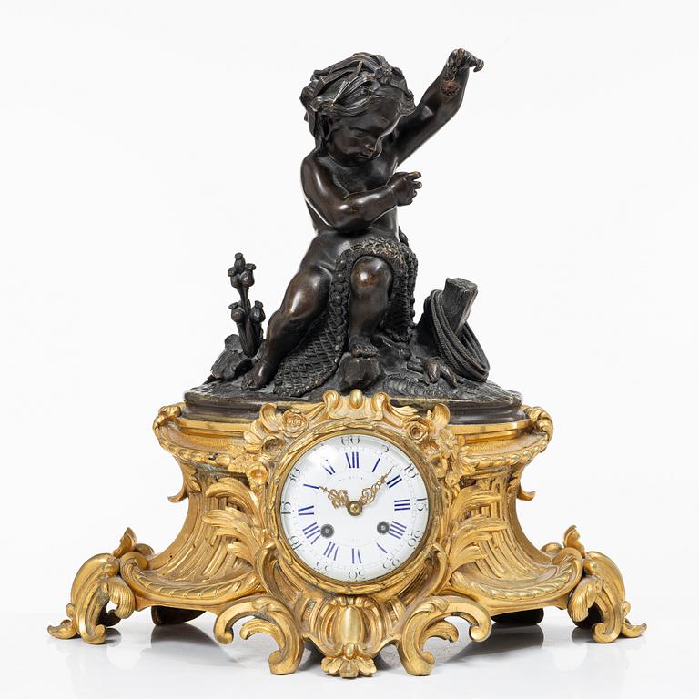 A Rococo style mantle clock and pair of candelabra, France, late 19th Century.