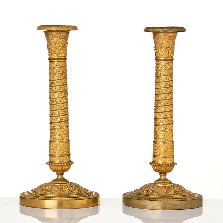 A pair of French Empire ormolu candlesticks, early 19th century.