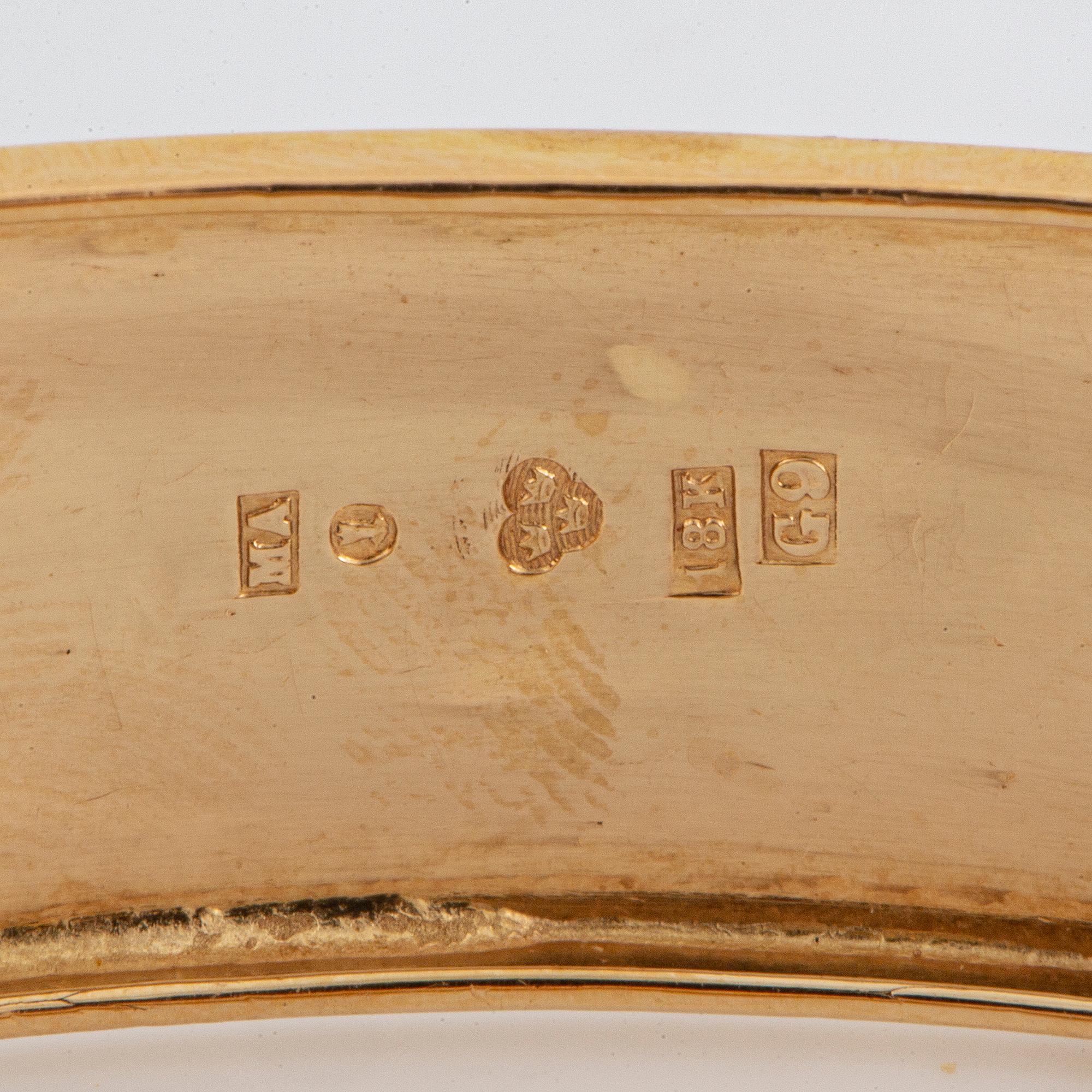 An 18K gold bangle.