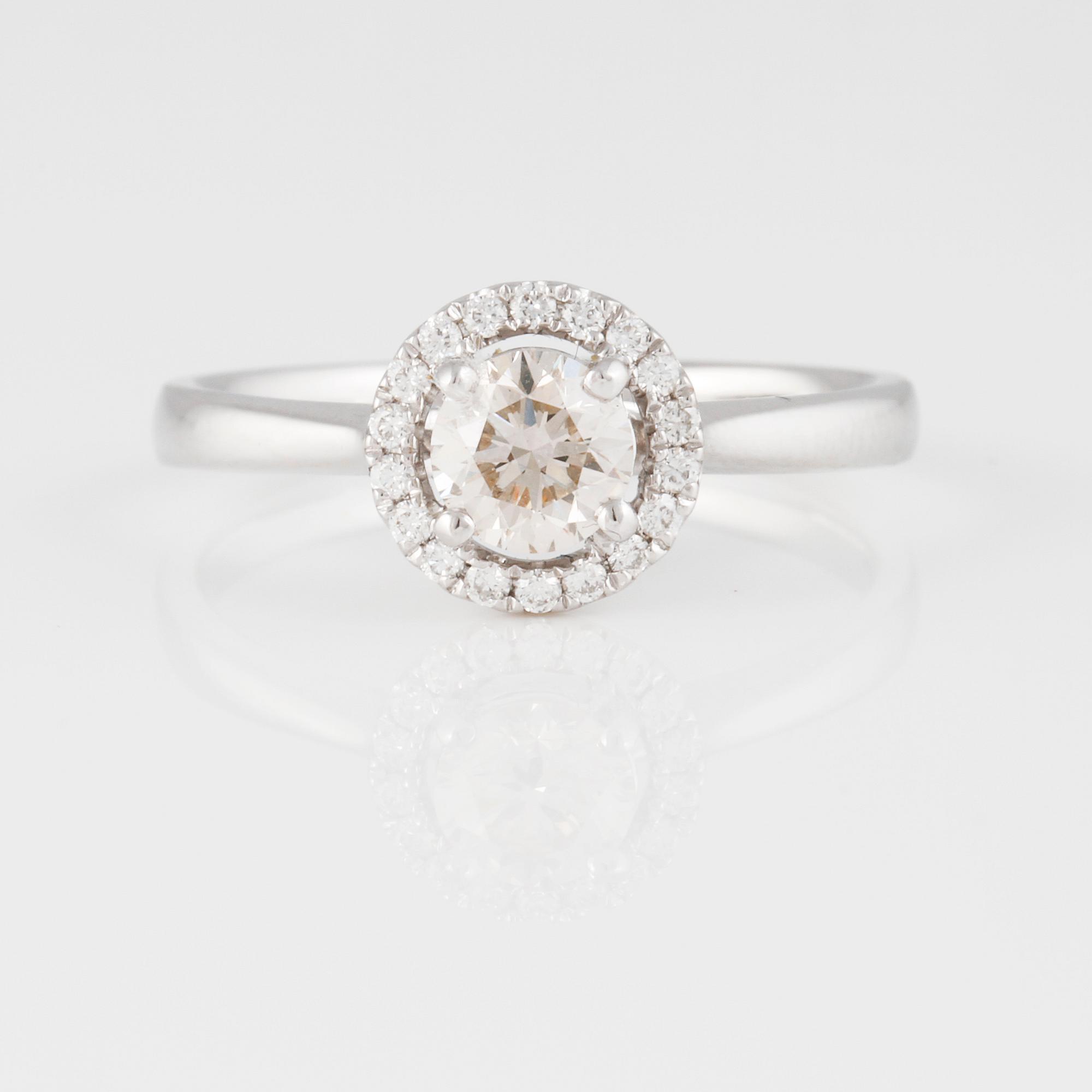 RING, 18K vitguld med briljantslipad diamant ca 0.50 ct samt små briljantslipade diamanter ca 0.10 ct. Vikt 3,0 gram.