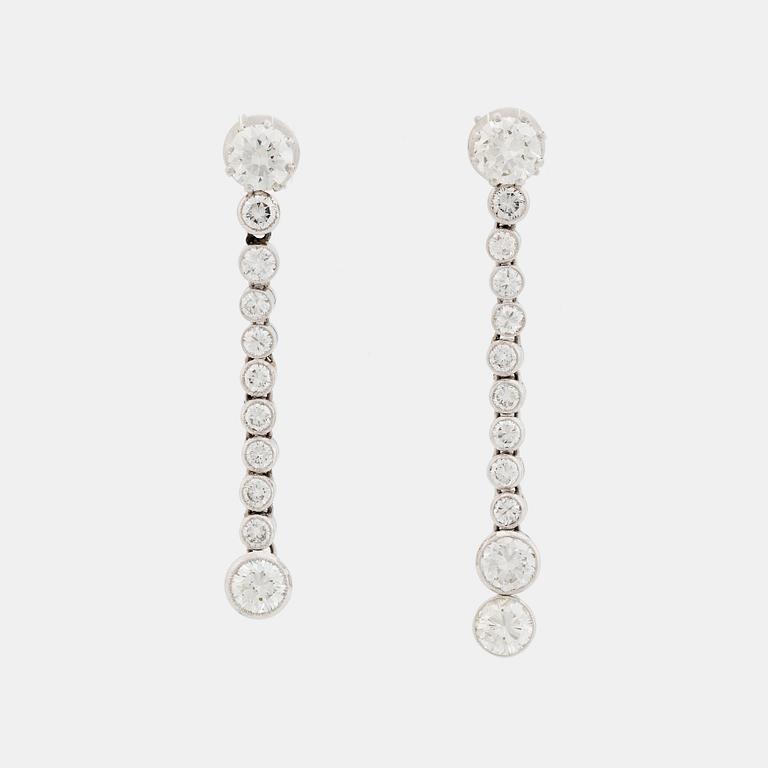 A pair of 18K white gold earrings set with round brilliant-cut diamonds.