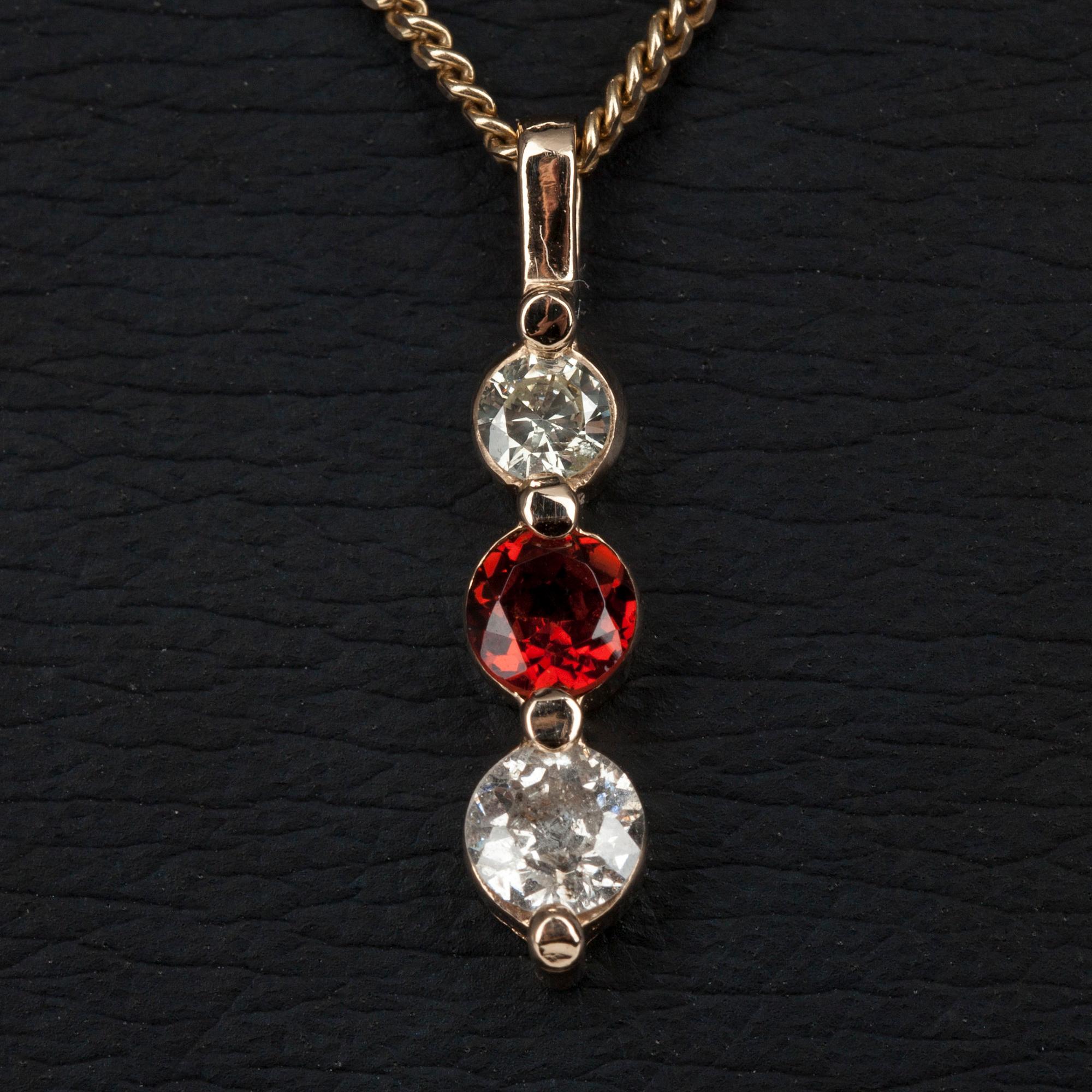 HÄNGE I KED, guld 14K, 2 diamanter tot. 0,34 ct, och en granat 0,32 ct. Vikt 4,1 g.