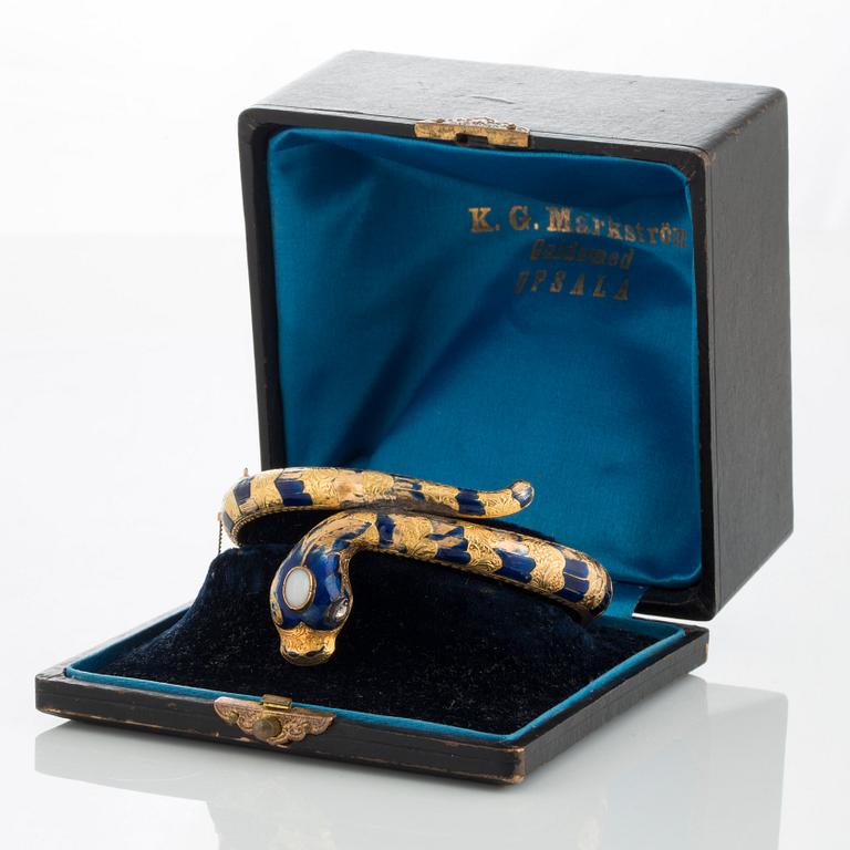 An 18K gold snake bangle decorated with blue enamel and set with an opal and a rose-cut diamond.