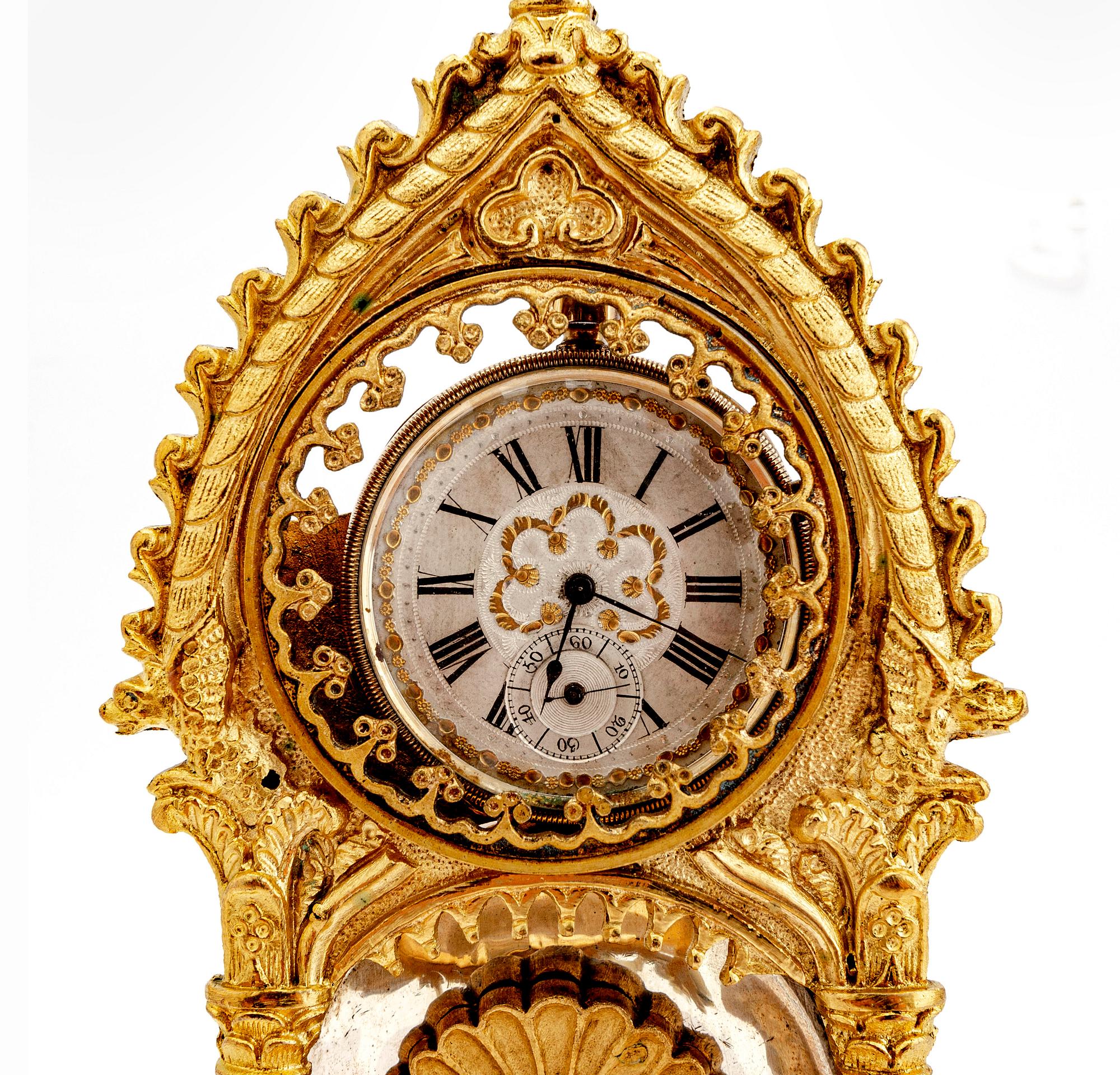 A mid 1800s gilded bronze pocket watch stand and pocket watch.