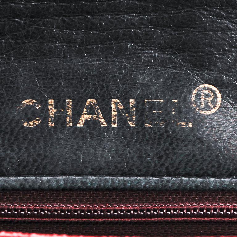 CHANEL, a black leather quilted purse with shoulder strap.