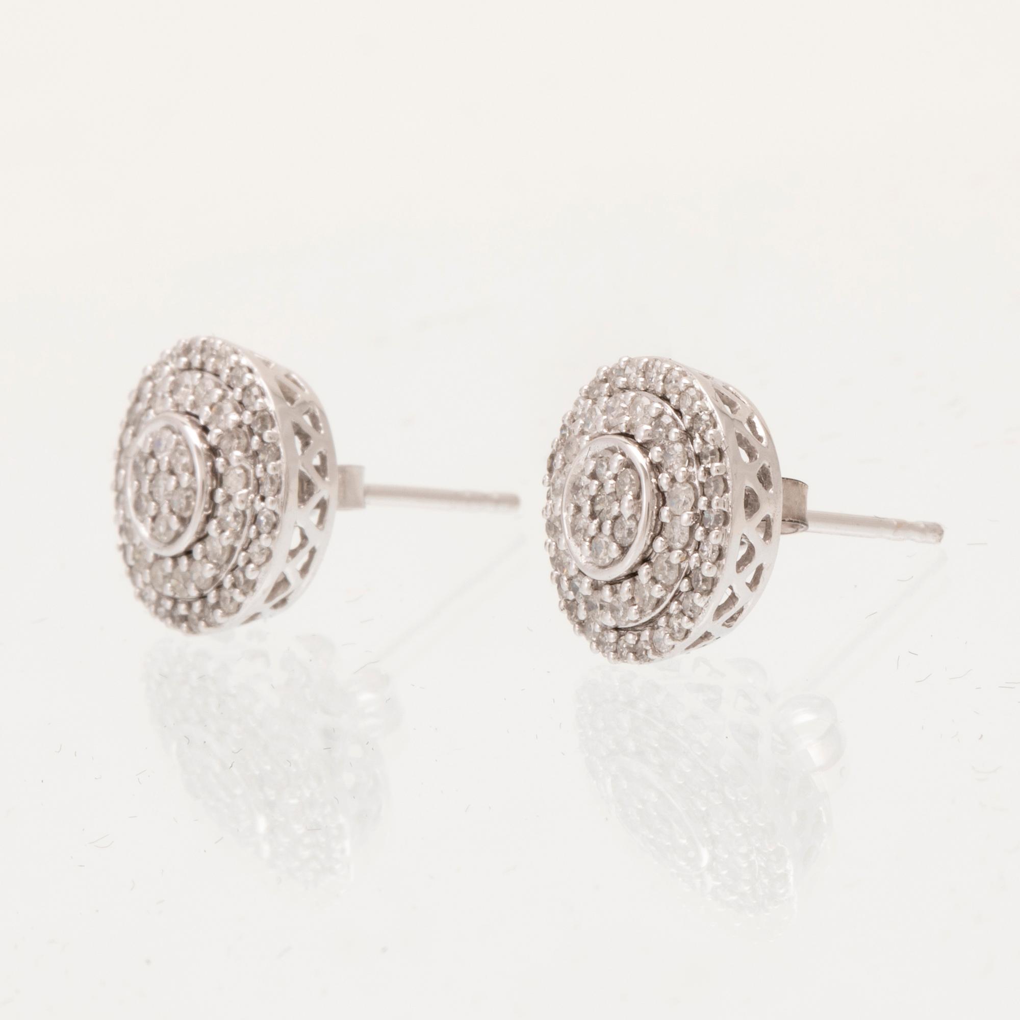 A pair of 14K white gold earrings set with round single-cut diamonds.
