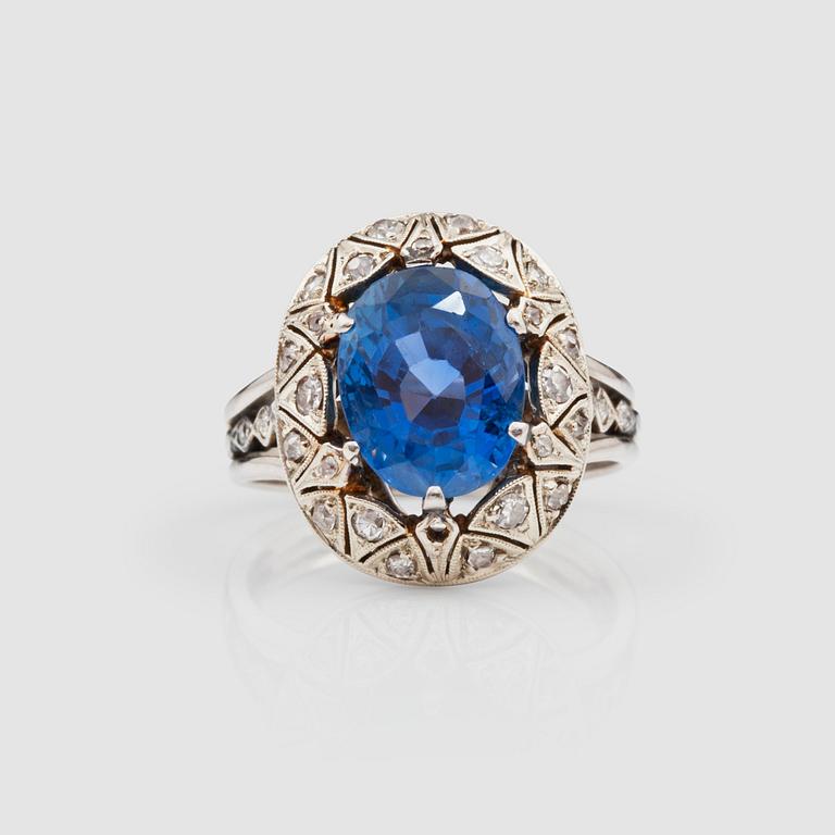 A circa 9.95 ct Ceylon sapphire surrounded by old-cut diamonds, total carat weight circa 0.40 ct.