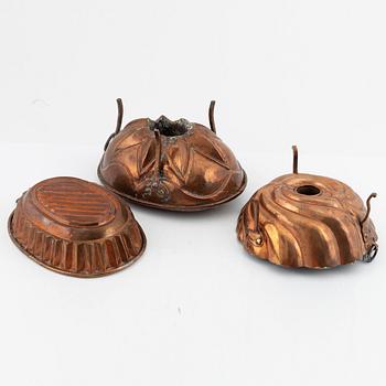 Four cake moulds, and a funnel, copper, 18th and 19th Century.