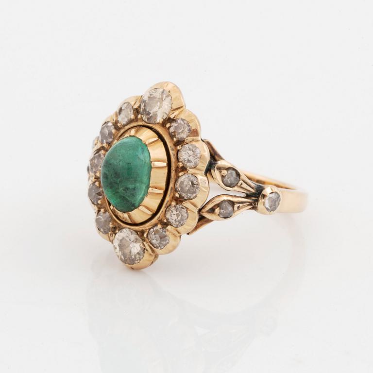 A 14K gold ring set with a cabochon-cut emerald and old-cut diamonds.