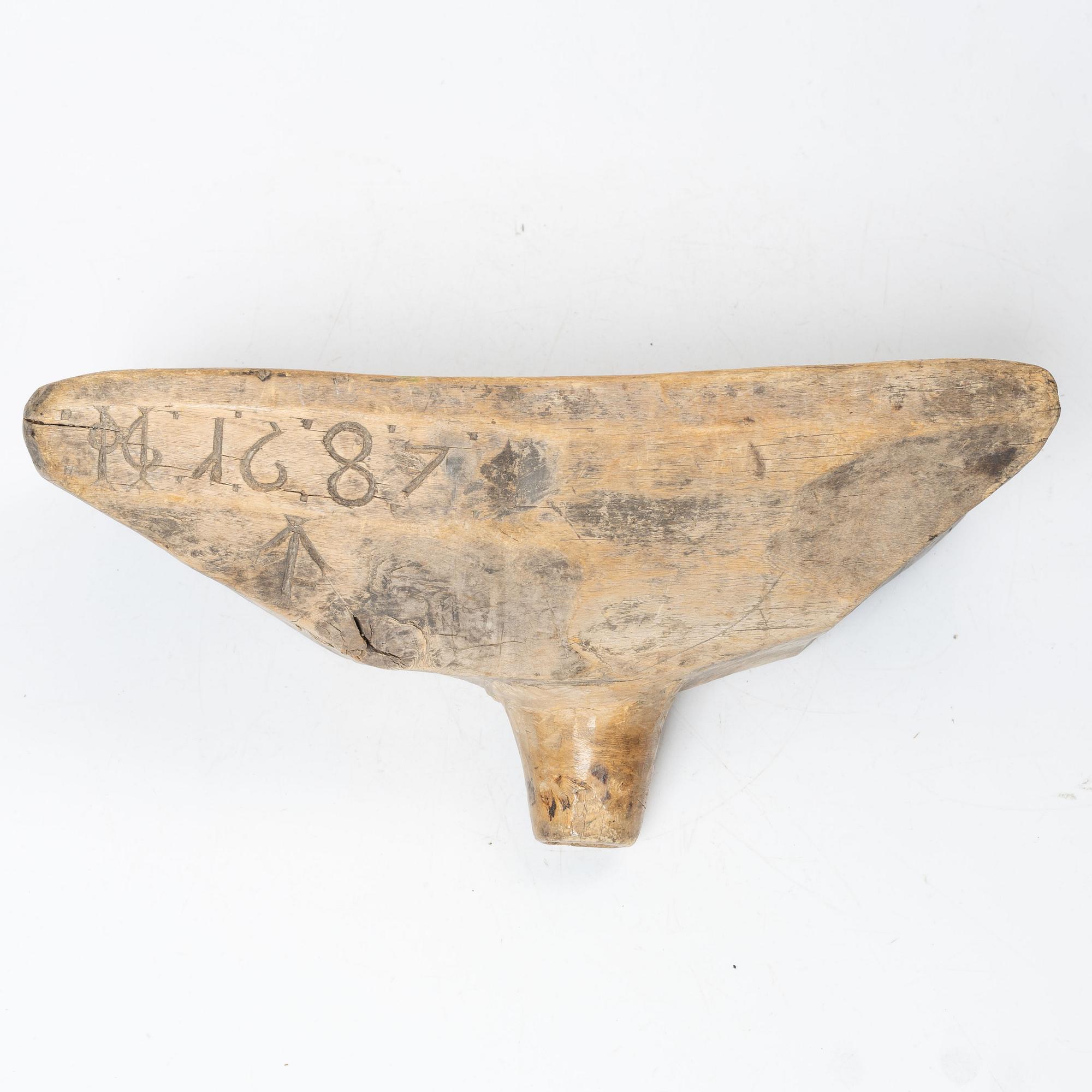 A Swedish carved wood milk funnel, dated 1687.