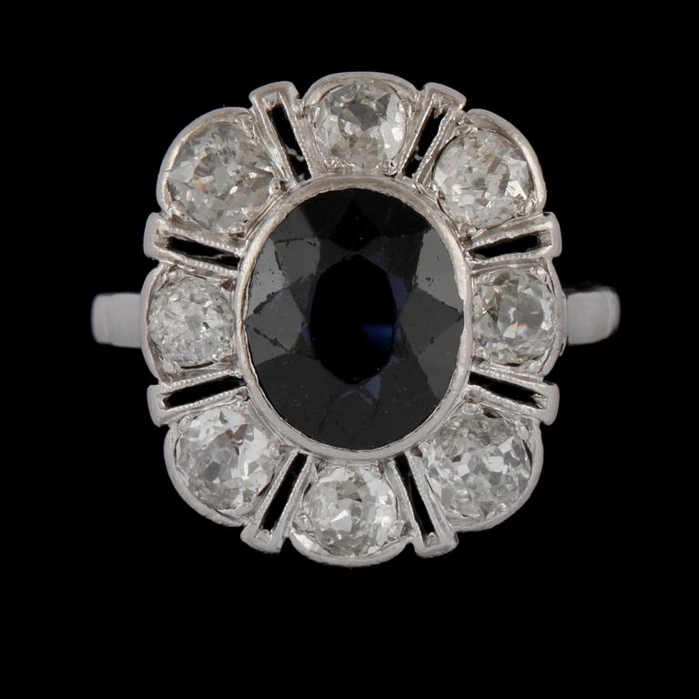 RING, platina med äldre briljantslipade diamanter samt ovalslipad blå safir, 1900-talets början. Vikt.