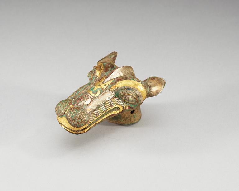 An archaistic bronze handle for a cane in the shape of a mythological animal.