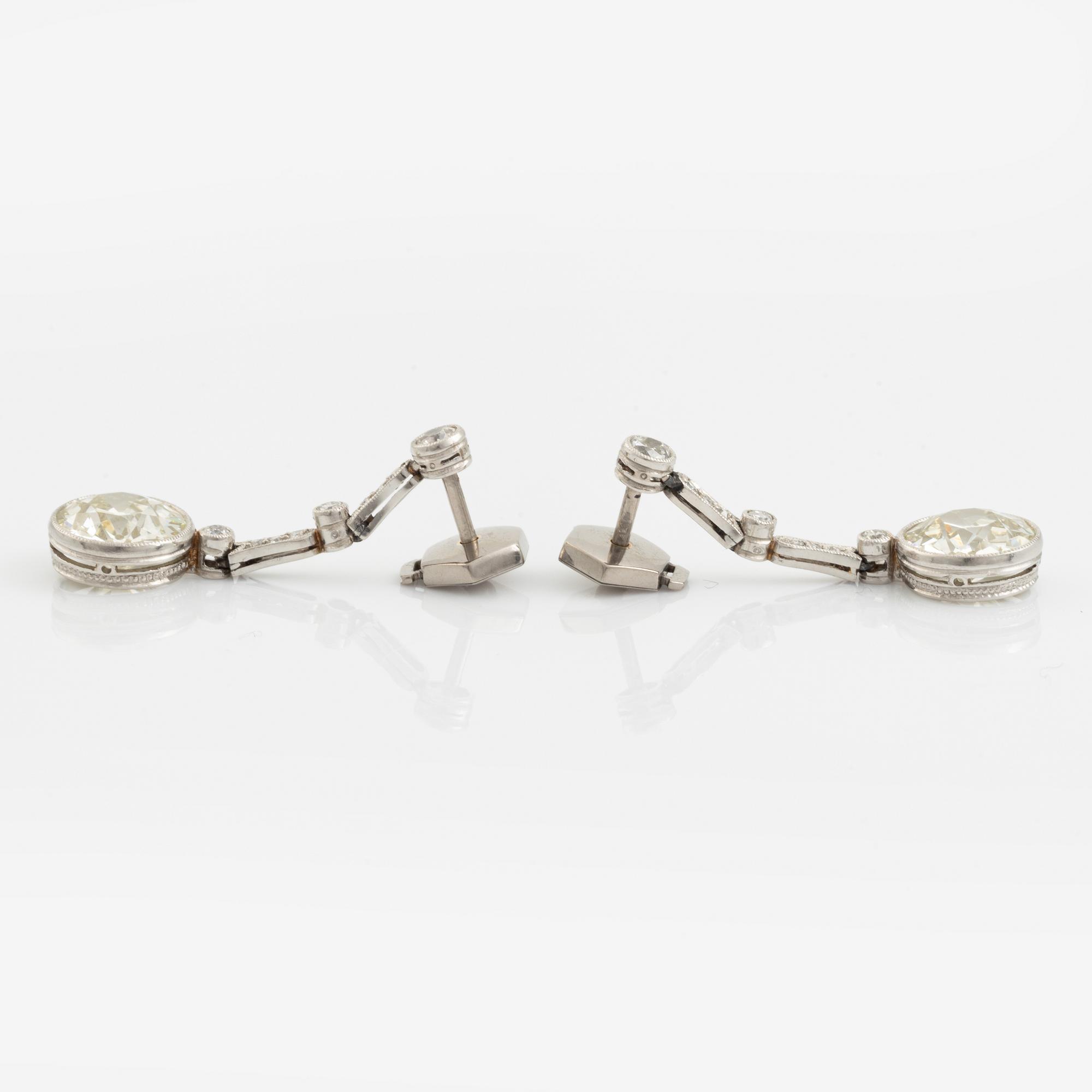 A pair of platinum earrings with two larger old-cut diamonds.