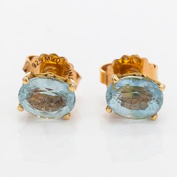 A pair of 18K gold earrings, one topaz and one aquamarine.