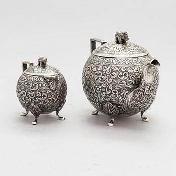 A silver teapot and milk jug, around the turn of the 20th century.