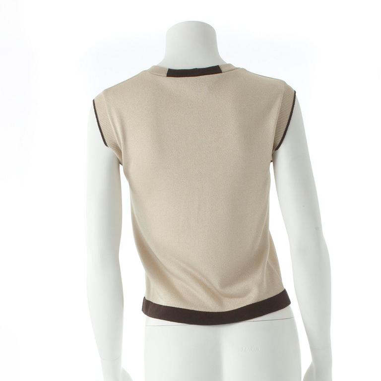 CHANEL, a gold colored and brown sweater set consisting of a sleevles top and cardigan.