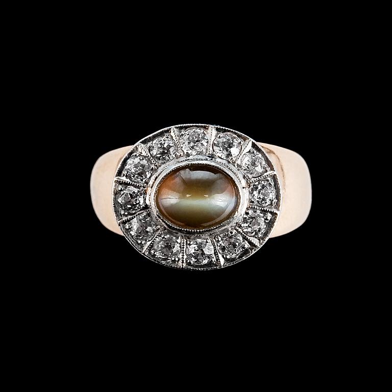 RING, 14K guld, 12 antikslipade diamanter ca 0.60 ct, krysoberyll kattöga 6 x 8 mm. Finland 1960-tal. Vikt 10g.