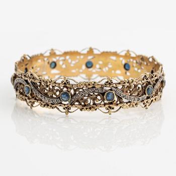 Bangle 18K gold and silver with rose-cut diamonds and blue stones, possibly sapphires.