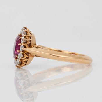 A ring set with oval, mixed-cut, untreated ruby surrounded by old cut diamonds.