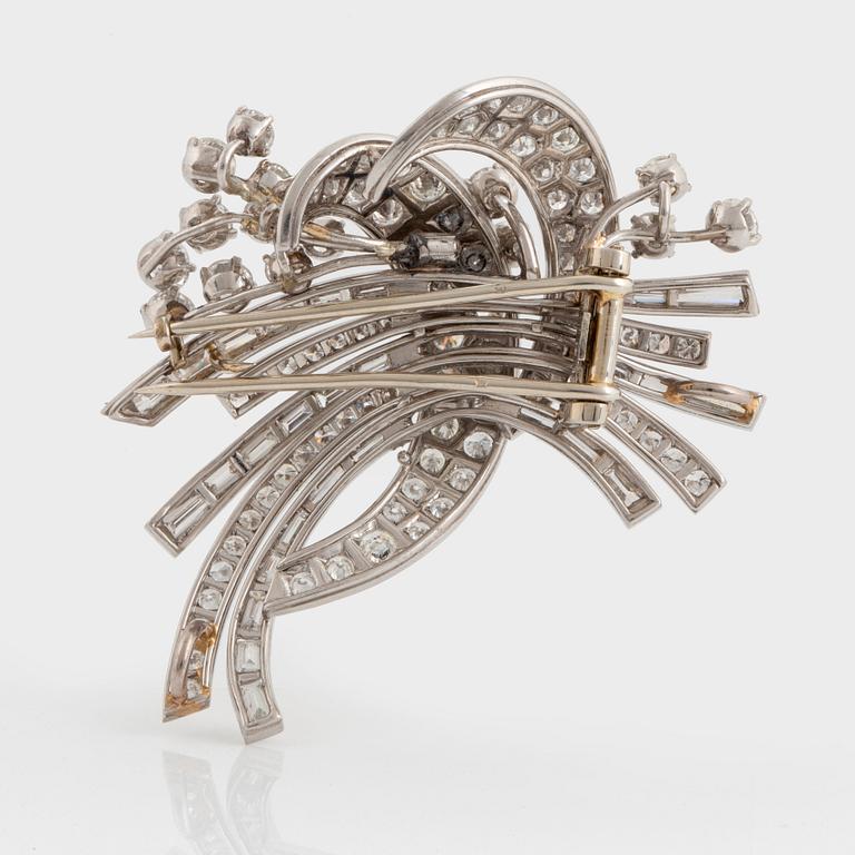 A platinum and 18K gold brooch set with round brilliant- and baguette-cut diamonds.