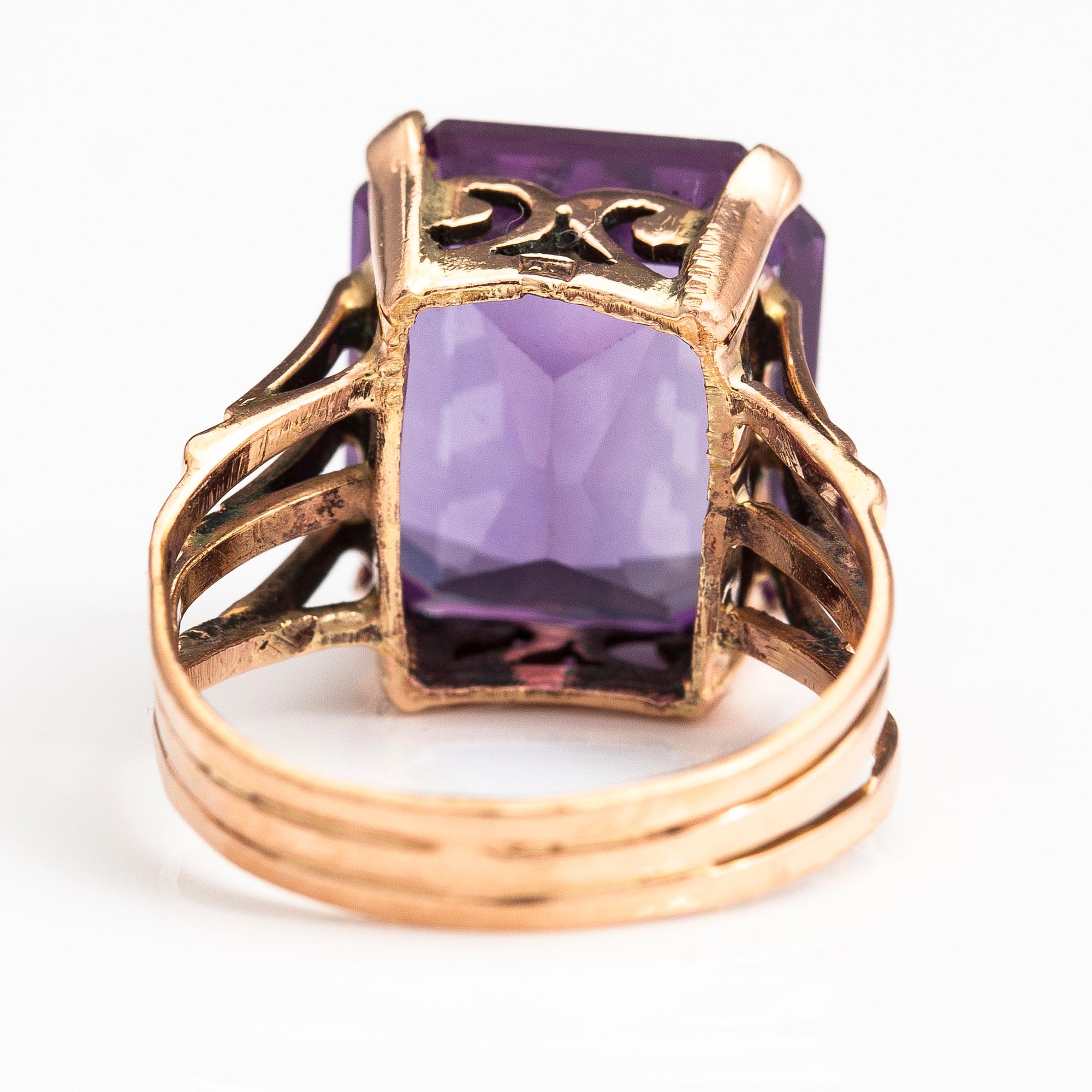 A 9-14K gold ring with a synthetic sapphire.
