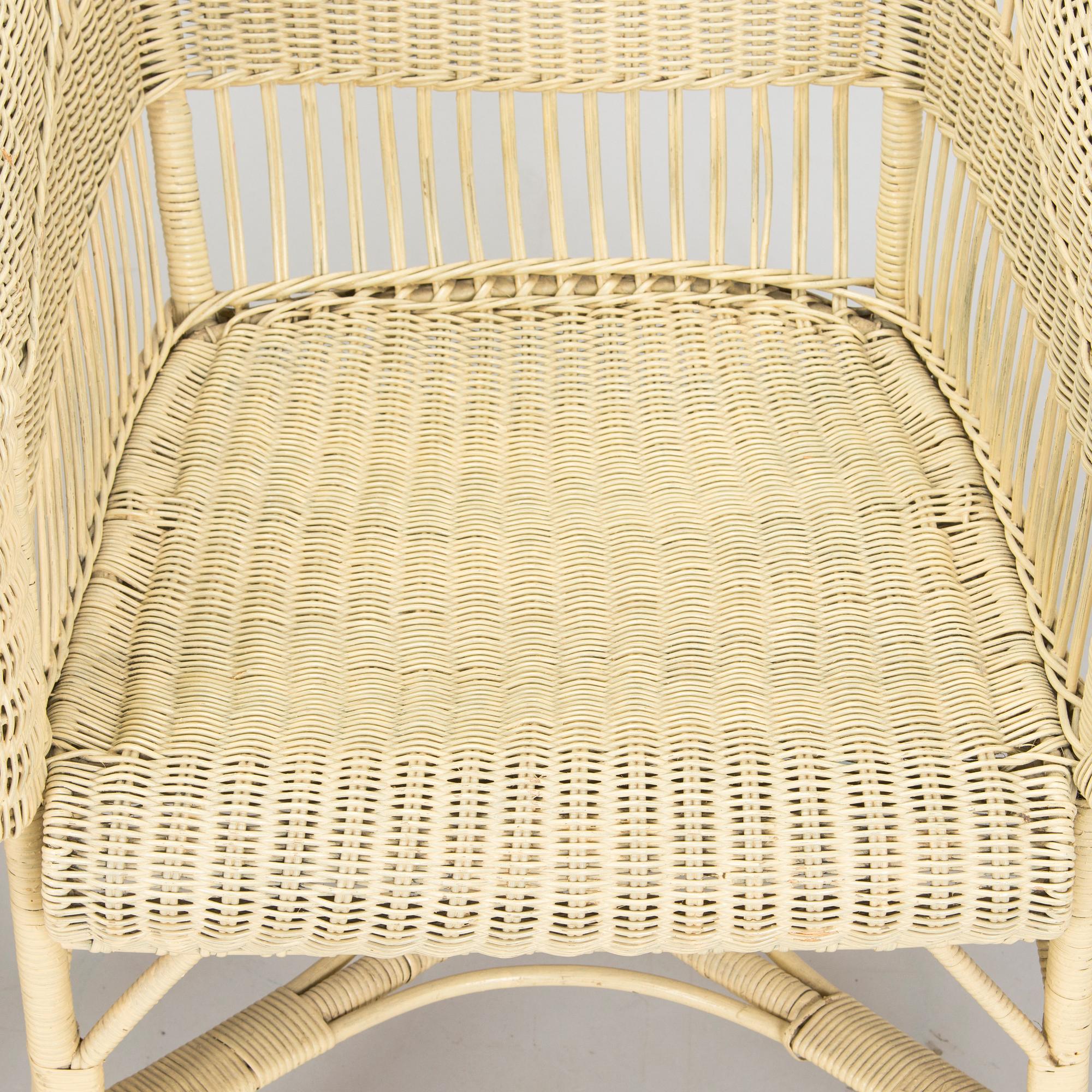 A mid-20th-century three-piece rattan furniture set including two armchairs, and a table.
