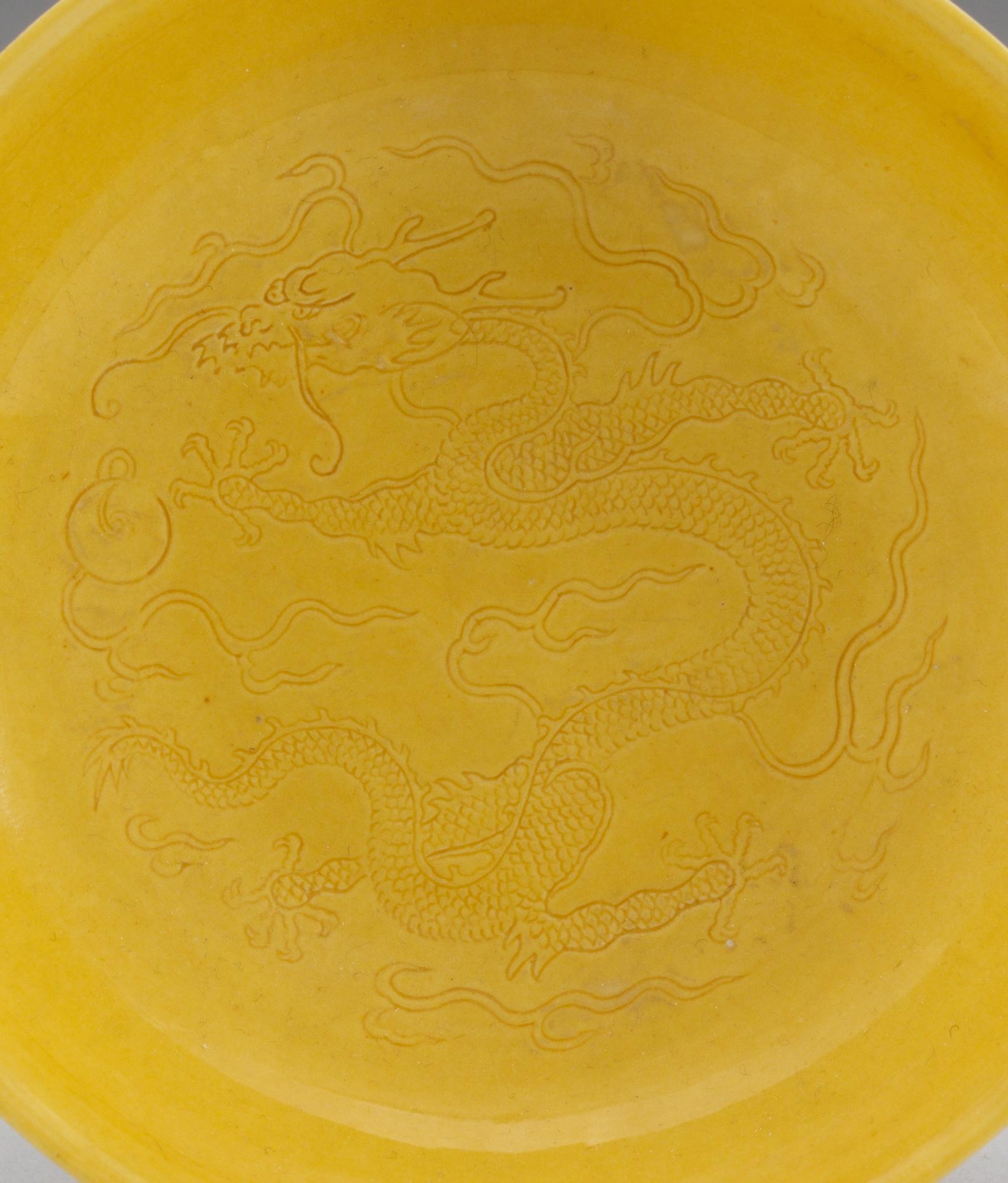 A pair of yellow-glazed incised dragon dishes, Qing dynasty with Qianlongs seal mark (1644-1912).