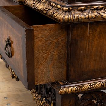 a baroque-style vitrine cabinet from the first half of the 20th century.