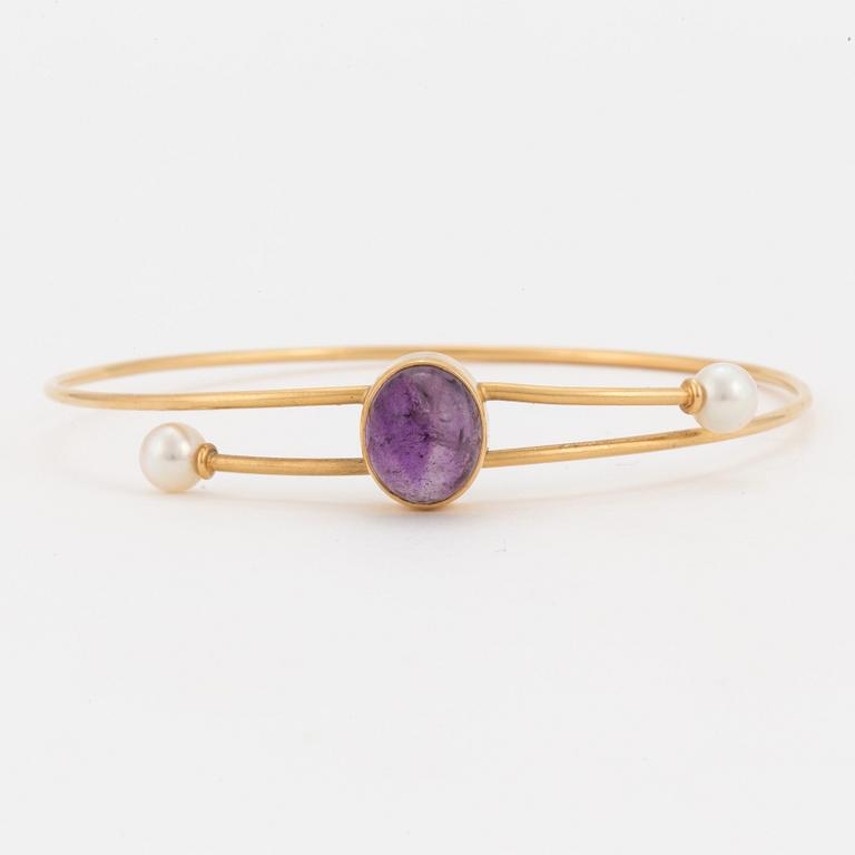 A bangle set with a cabochon-cut amethyst and cultured pearls.