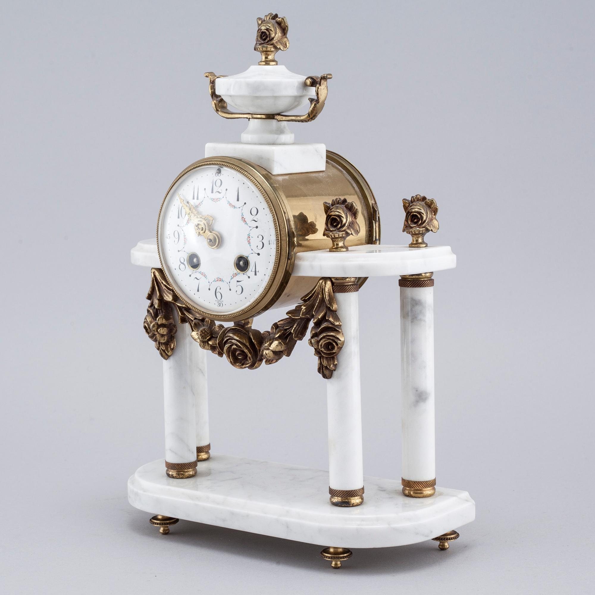 A French mantlepiece clock and a pair of candelabras, first half of the 20th century.