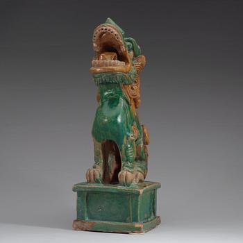 A green and yellow glazed pottery figure of a buddhist lion, presumably Ming dynasty.