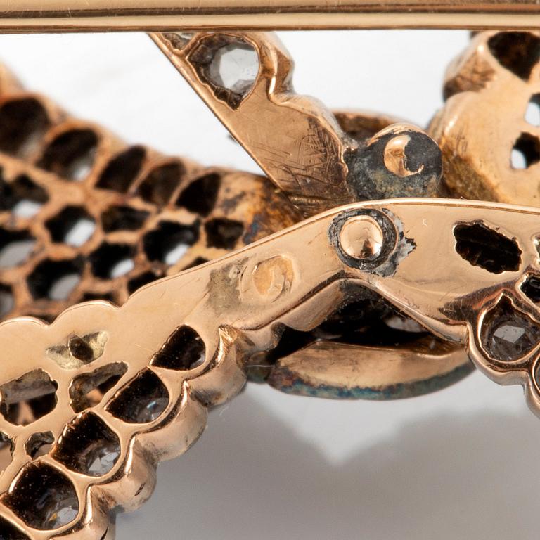 A 14K gold brooch set with old-cut diamonds.