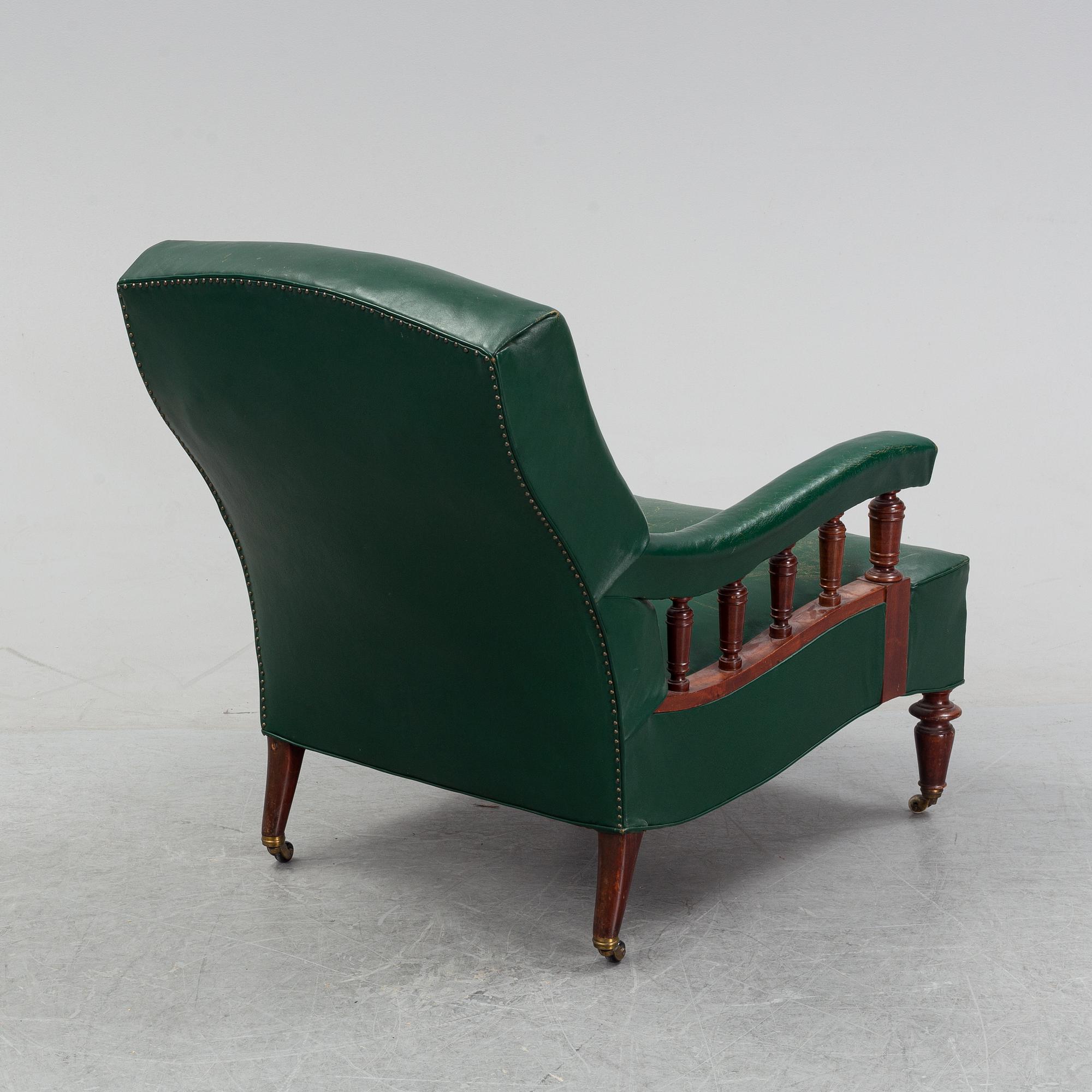 An early 20th Century easy chair with leather upholstery.