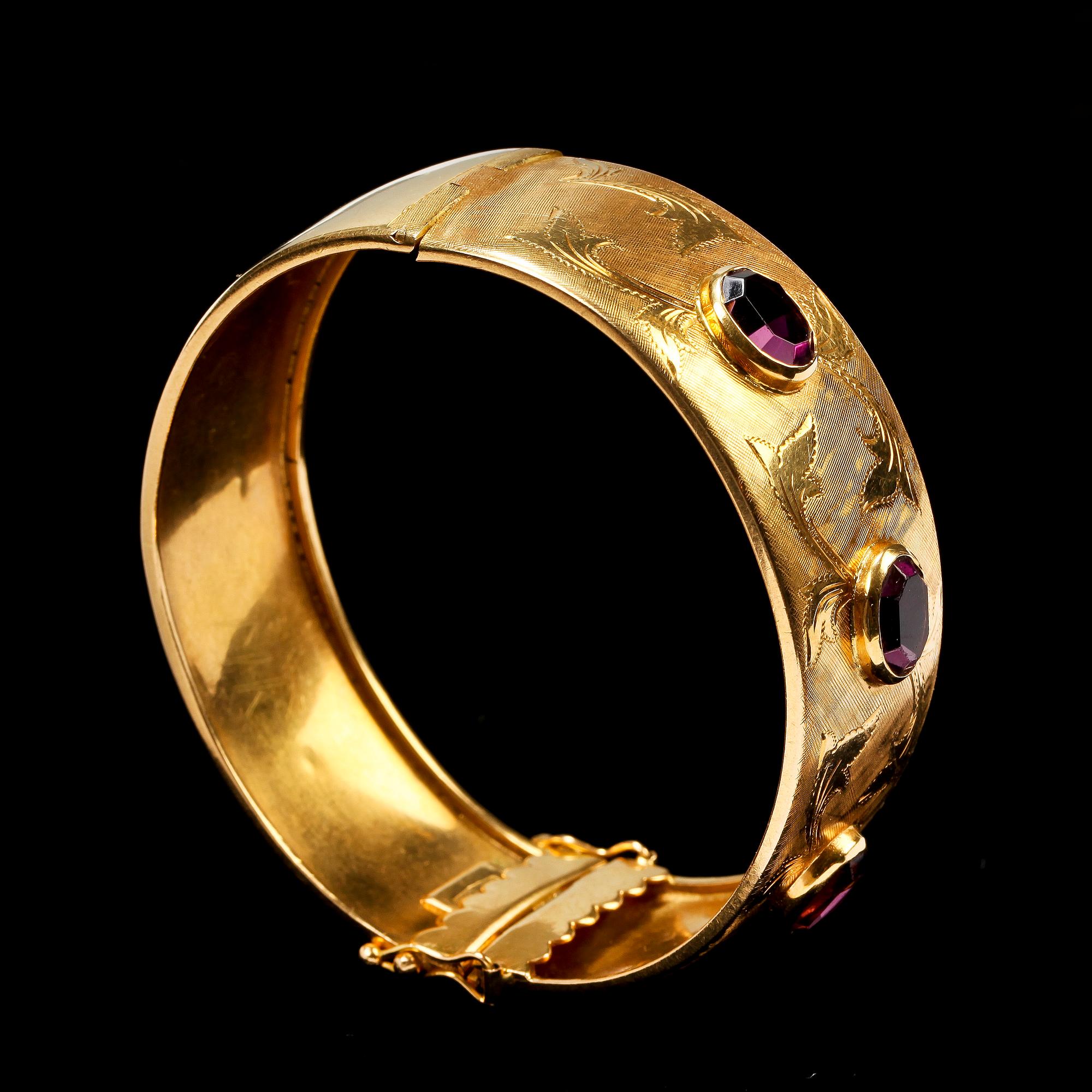 ARMBAND. 18k guld med tre ovalslipade lila stenar. 28g.