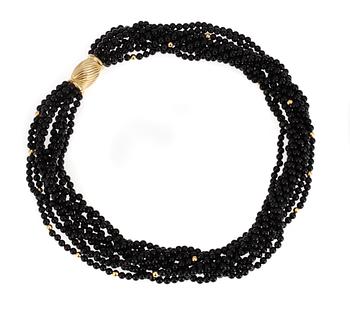 660. NECKLACE, 9 strands of onyx with gold locket.