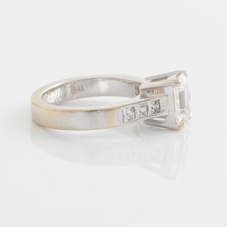 An 18K white gold ring set with an emerald-cut diamond.