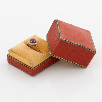 Ring in 18K gold set with a faceted synthetic ruby and eight-cut diamonds.