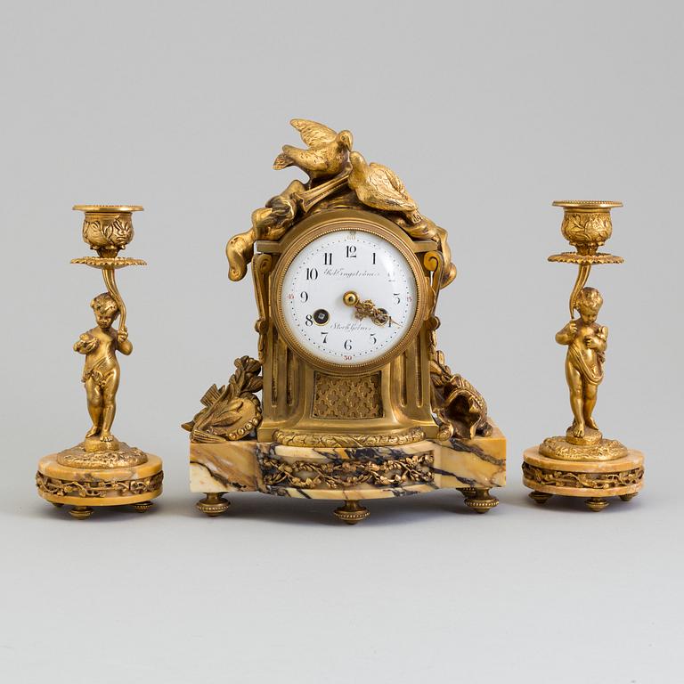 A mantle clock and a pair of candlesticks, early 20th century.