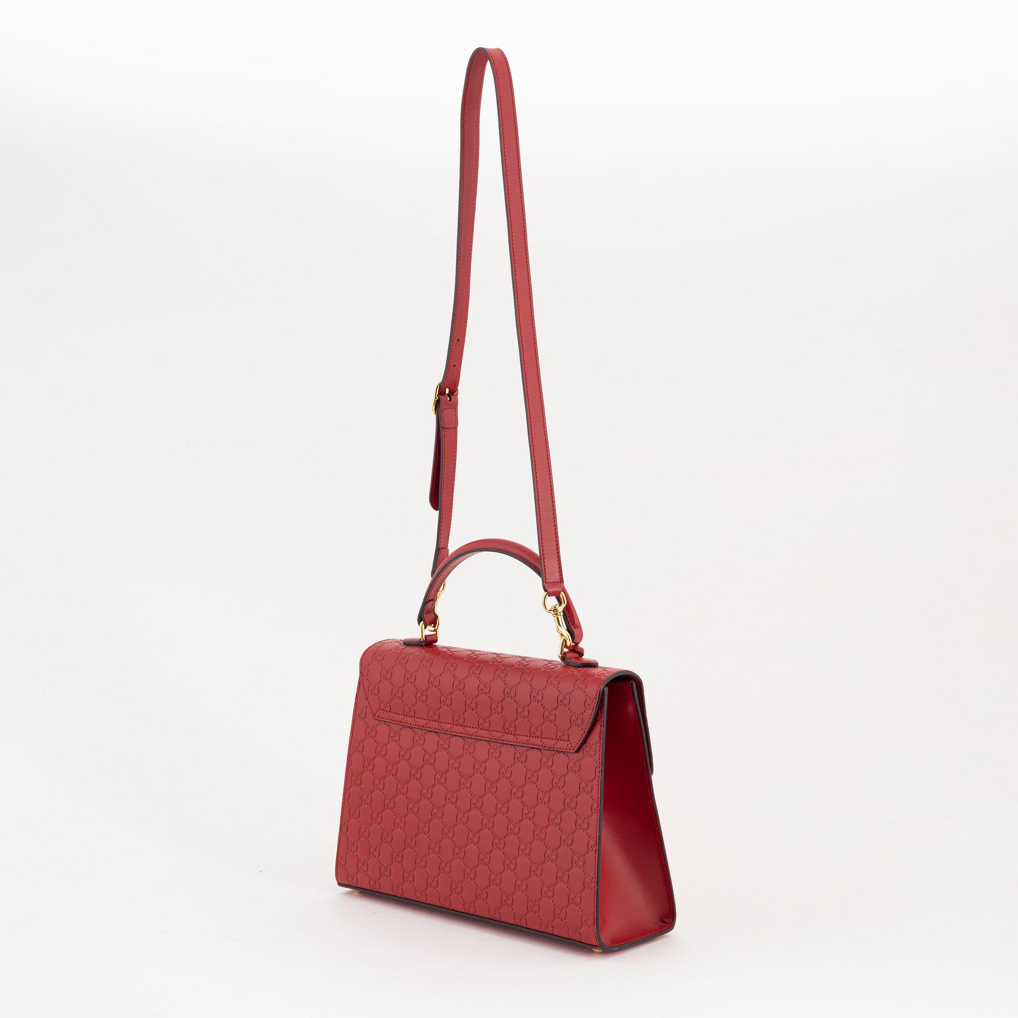 Gucci, a red, embossed leather handbag.