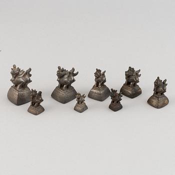 Eight metal opium weights.