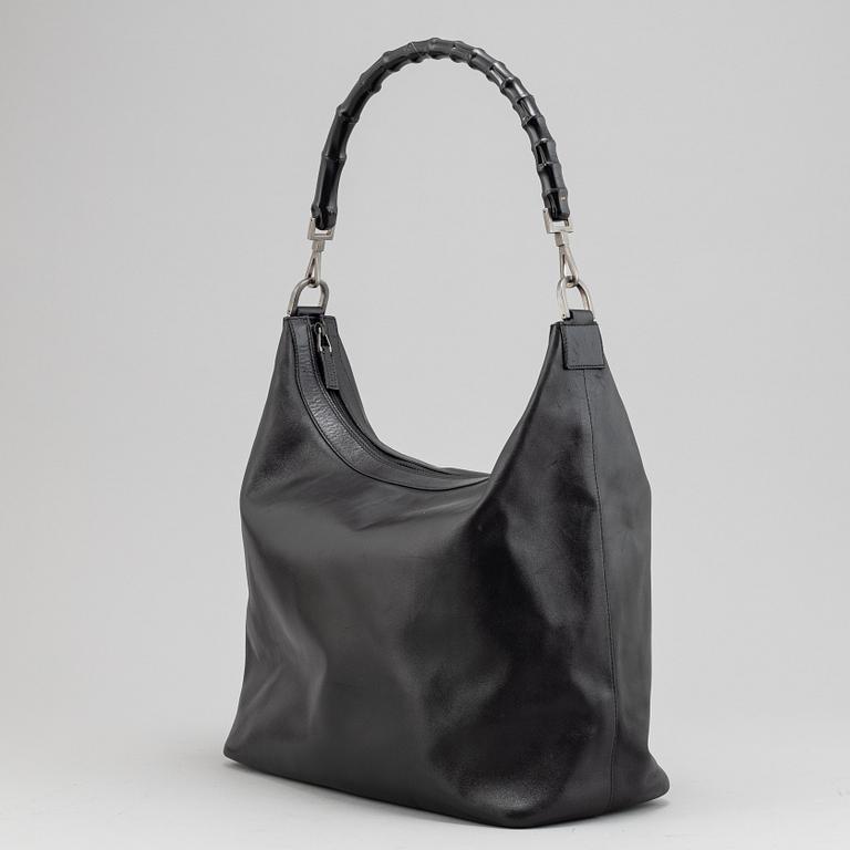 Gucci, a black leather handbag.