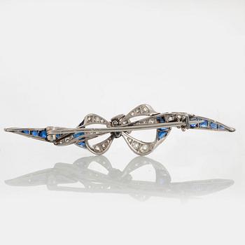 A platinum brooch set with old-cut diamonds and faceted sapphires.