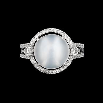 1020. A ring with cabochon cut moonstone 4 cts and diamonds tot. app. 0.54 cts.