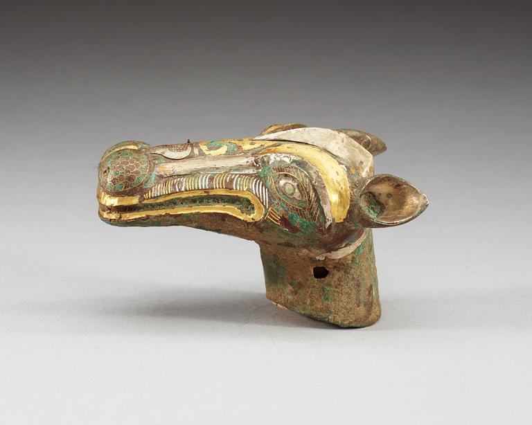 An archaistic bronze handle for a cane in the shape of a mythological animal.